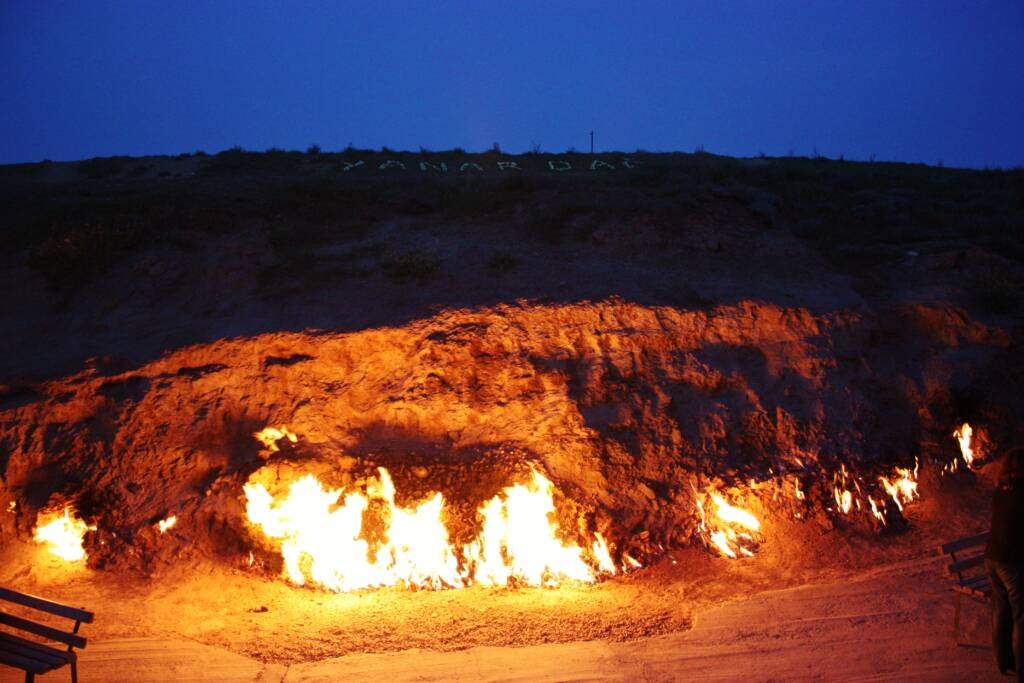 Natural gas flames burning continuously on the hillside of Yanar Dağ (Fire Mountain) on the Absheron Peninsula near Baku, photographed at dusk against a darkening sky to do in Baku Baku travel guide 2026