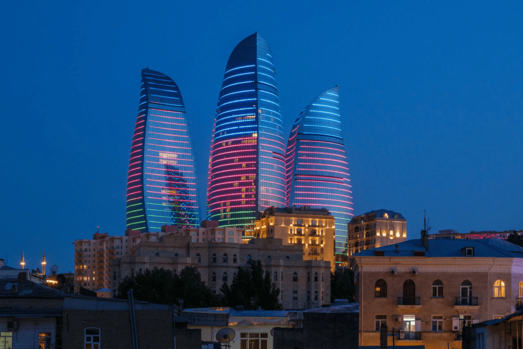 The three Flame Towers illuminated at night in Baku, Azerbaijan, their LED panels creating dynamic flame animations that reflect in the Caspian Sea boulevard below  to do in Baku Baku travel guide 2026