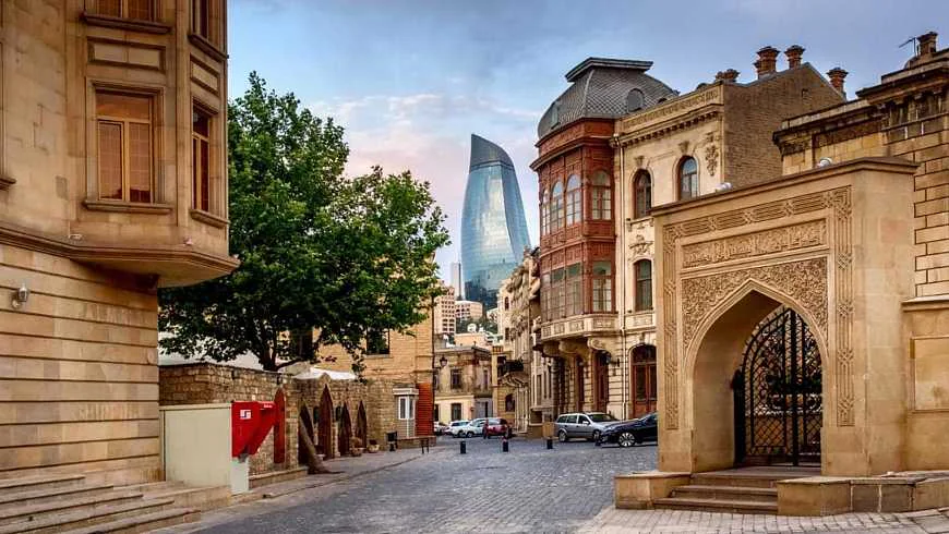  Bakının İçərişəhərindəki (Köhnə Şəhər) dar daş döşəməli küçələr — orta əsr divarları və arxa planda Qız Qalası Bakı gəzinti yeri 2026, Bakı Azərbaycan turistik yerlər, Xəzər dənizi yaxta Bakı, Alov Qüllələri Bakı, İçərişəhər, Gobustan, Heydər Əliyev Mərkəzi, Bakı turizm, Bakı bələdçisi.Bakıda nə etmək olar