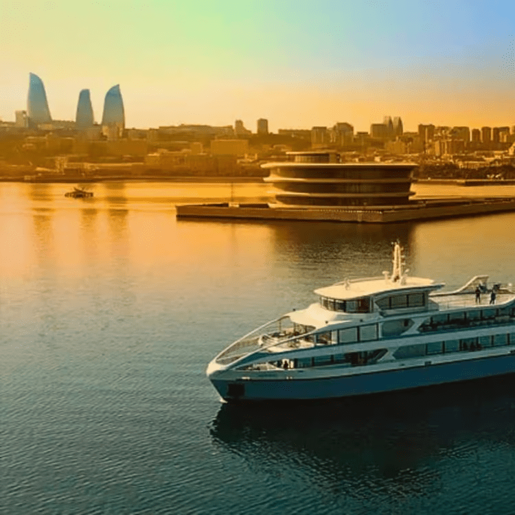 Xəzər dənizindəki özəl charter yaxtasının göyərtəsindəki qonaqlar — Alov Qüllələri üzərindəki gün batarkən Bakının işıqlı siluetini izləyirlər Bakı gəzinti yeri 2026, Bakı Azərbaycan turistik yerlər, Xəzər dənizi yaxta Bakı, Alov Qüllələri Bakı, İçərişəhər, Gobustan, Heydər Əliyev Mərkəzi, Bakı turizm, Bakı bələdçisi.Bakıda nə etmək olar